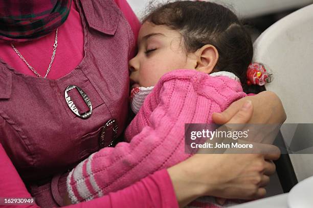 Child sleeps as her mother, a recently-arrived refugee from Iraq, learns how to receive food stamps during a class held by the Arizona Department of...