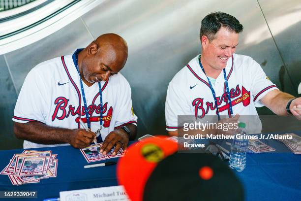 Former Atlanta Braves Matt Diaz and Michael Tucker sign autographs during Braves alumni weekend before the game against the San Francisco Giants at...