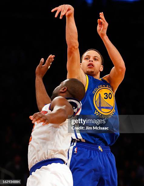 Stephen Curry of the Golden State Warriors shoots a three point basket in the fourth quarter against Raymond Felton of the New York Knicks at Madison...