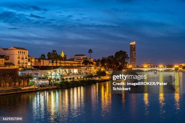 triana neighbourhood on the banks of the guadalquivir river at dusk, seville, andalusia, spain - provincia de sevilla stock pictures, royalty-free photos & images