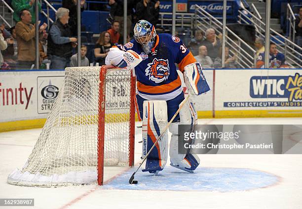 Rick DiPietro of the Bridgeport Sound Tigers reacts as he clears the puck from the net after allowing one of five goals during the first period of an...