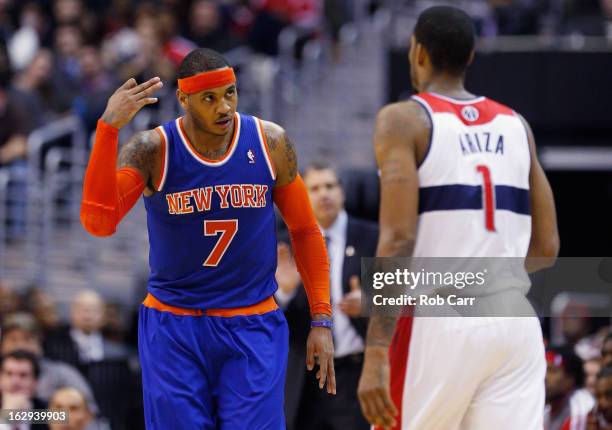 Carmelo Anthony of the New York Knicks celebrates in front of Trevor Ariza of the Washington Wizards after hitting a three point basket during the...