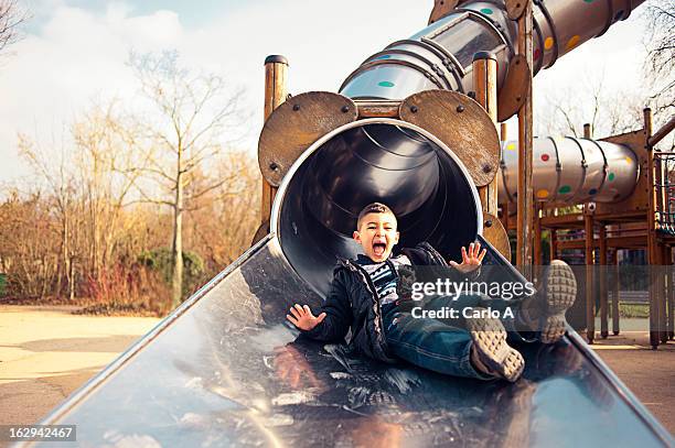 boy at playground - slide photos et images de collection