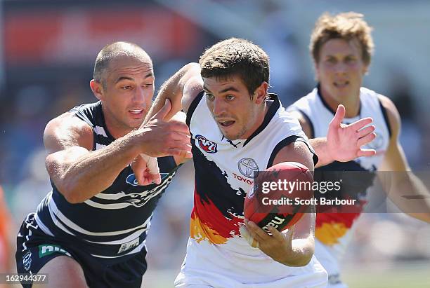 Ricky Henderson of the Crows is tackled by James Podsiadly of the Cats during the round two AFL NAB Cup match between the Geelong Cats and the...