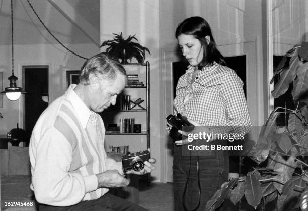 Gordie Howe shows his daughter Cathy a camera at their home circa 1980 in Bloomfield Hills, Michigan.