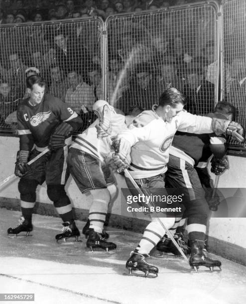 Gordie Howe and Red Kelly of the Detroit Red Wings battle with Dickie Moore and Maurice Richard of the Montreal Canadiens circa 1955 at the Detroit...