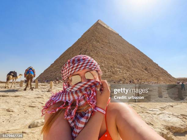 young woman taking selfies in front of the pyramids of giza in cairo - giza pyramids stock pictures, royalty-free photos & images