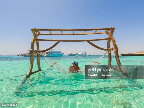 jeune femme allongée dans un hamac sur l’île paradisiaque en égypte - couché de soleil photos et images de collection