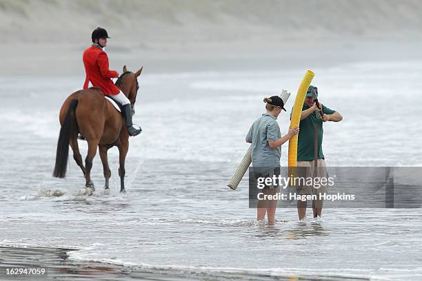 Course attendants install a marker during the Castlepoint Beach Races at Castlepoint Beach on March 2, 2013 in Masterton, New Zealand.