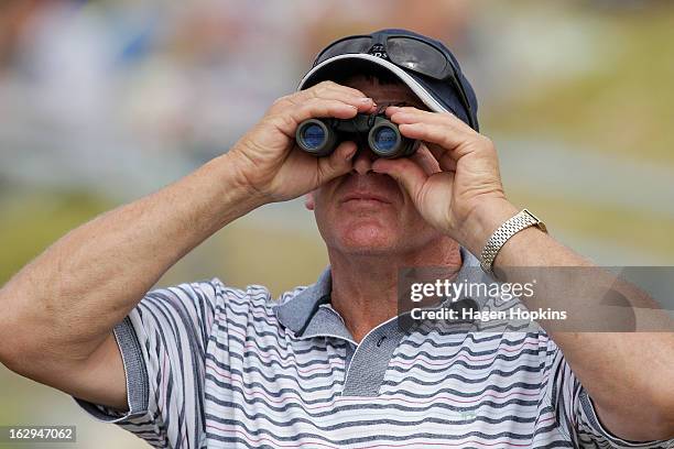 Spectator looks on through his binoculars during the Castlepoint Beach Races at Castlepoint Beach on March 2, 2013 in Masterton, New Zealand.