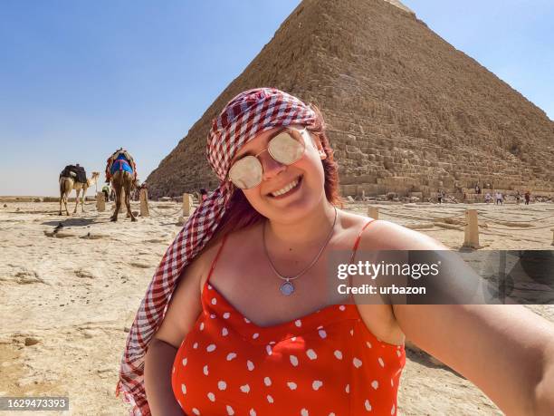 young woman taking selfies in front of the pyramids of giza in cairo - mykerinos pyramid bildbanksfoton och bilder