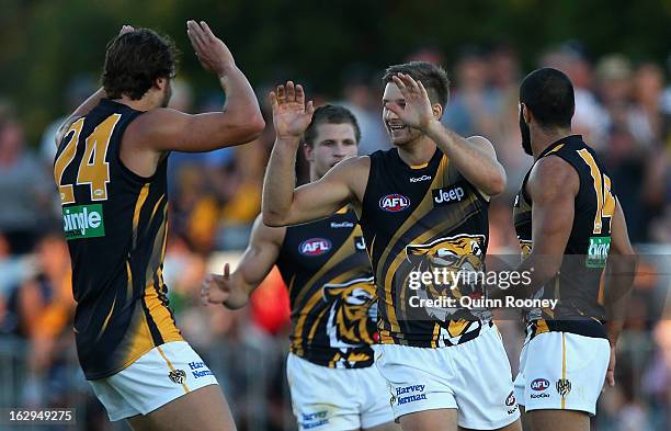 Ricky Petterd of the Tigers is congratulated by team mates after kicking a goal during the round two AFL NAB Cup match between the Essendon Bombers...