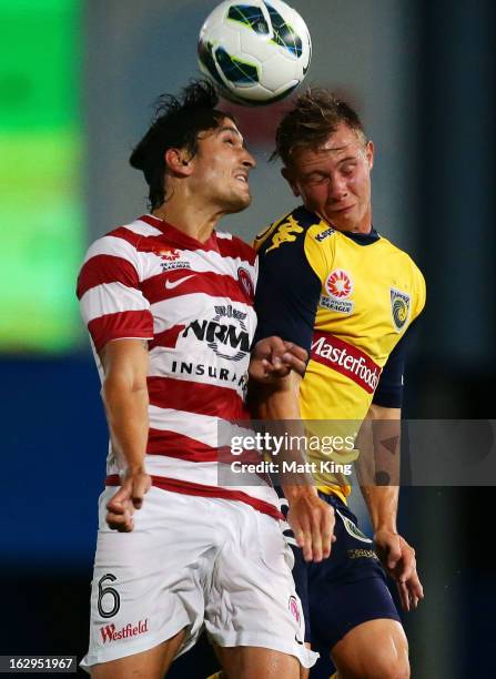 Nick Fitzgerald of the Mariners is challenged by Jerome Polenz of the Wanderers during the round 23 A-League match between the Central Coast Mariners...