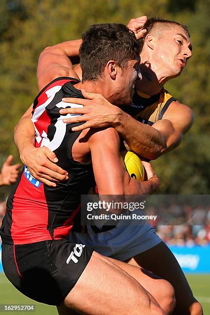 David Meyers of the Bombers is tackled by Dustin Martin of the Tigers during the round two AFL NAB Cup match between the Essendon Bombers and the...