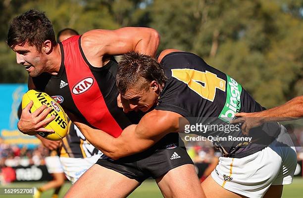 David Meyers of the Bombers is tackled by Dustin Martin of the Tigers during the round two AFL NAB Cup match between the Essendon Bombers and the...