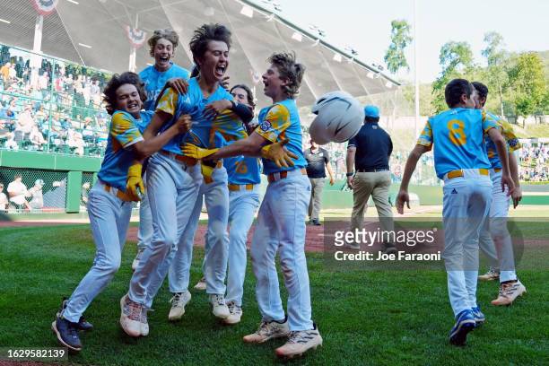 Louis Lappe of the West Region team from El Segundo, California celebrates with teammates after hitting a walk off home run to beat the Caribbean...