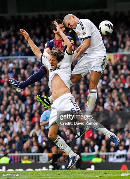 David Villa of FC Barcelona duels for a high ball with Fabio Coentrao and Pepe of Real Madrid CF during the La Liga match between Real Madrid CF and...