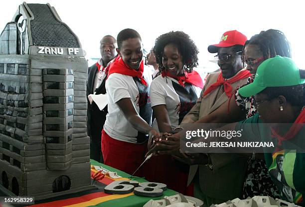 Zimbabwe's President Robert Mugabe cuts his birthday cake with the first family, his children Chatunga Mugabe and Bona Mugabe and his wife Grace...