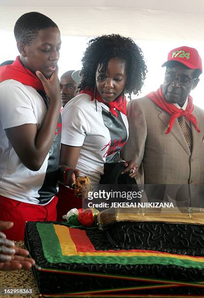 Zimbabwe's President Robert Mugabe cuts his birthday cake with the first family, his children Chatunga Mugabe and Bona Mugabe during a y21st February...