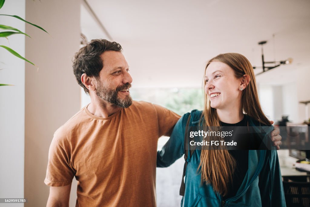 Father and daughter talking while walking at home