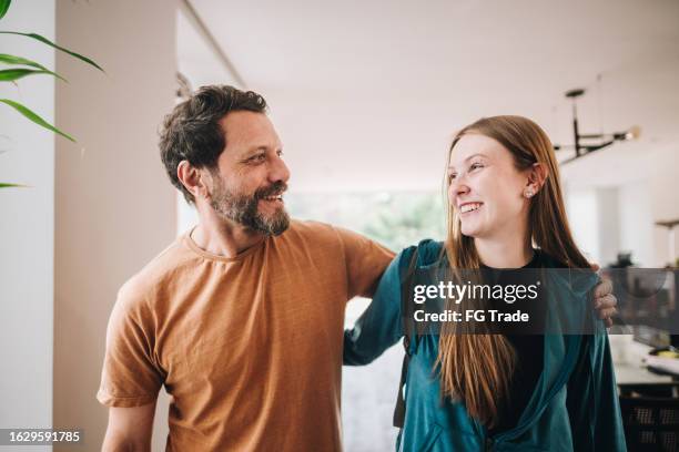 father and daughter talking while walking at home - parent stock pictures, royalty-free photos & images