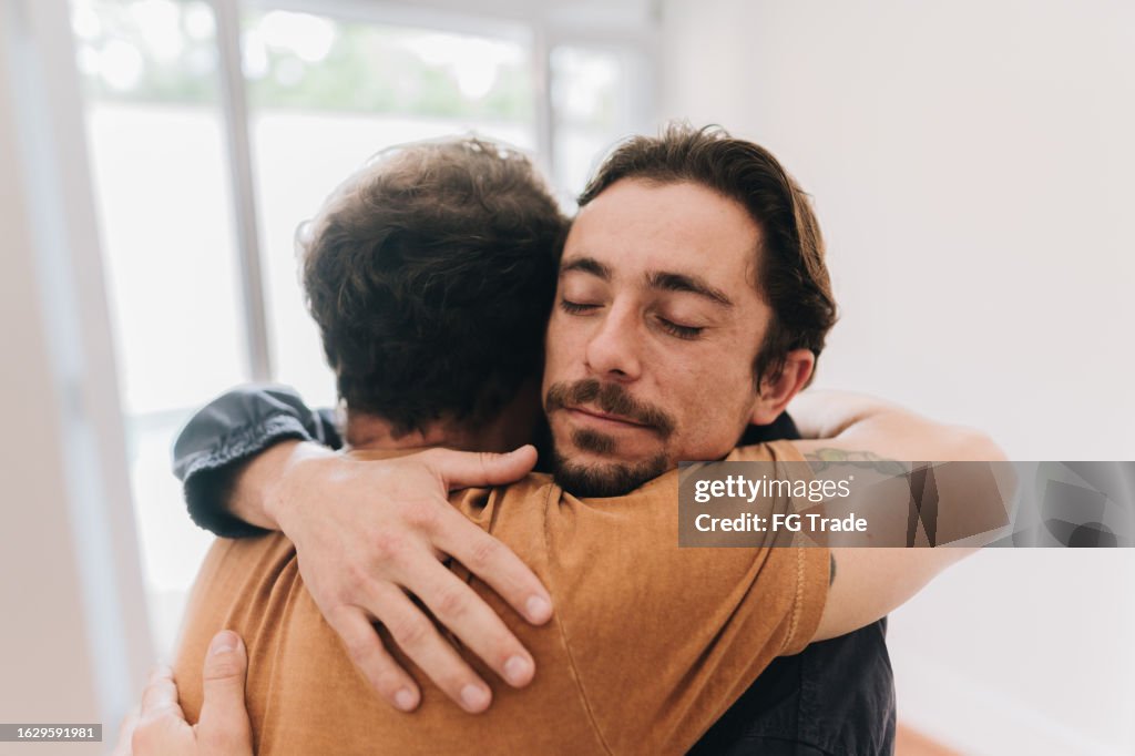 Pai e filho abraçados em casa