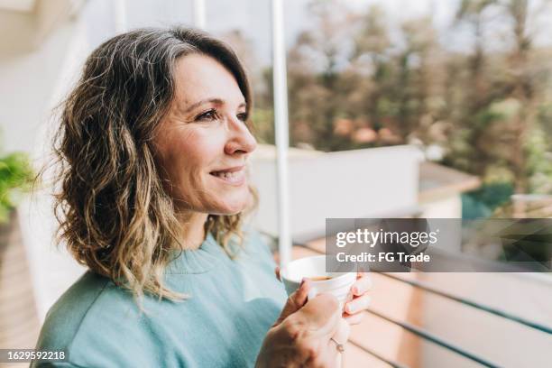 reife frau, die wegschaut und zu hause nachdenkt - generation x stock-fotos und bilder