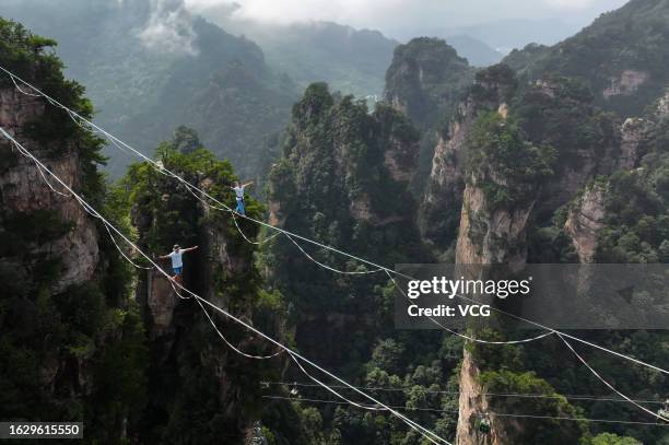 Slackine walkers compete on a slackine, 120 meters in legth and 2.5 centimeters in width, during a slackine challenge contest at an altitude of 1,092...