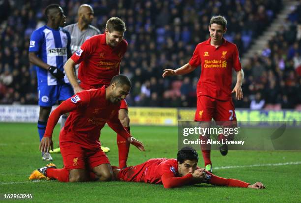 Luis Suarez of Liverpool celebrates with Glen Johnson and Steven Gerrard after scoring his third goal to complete a hat trick during the Barclays...