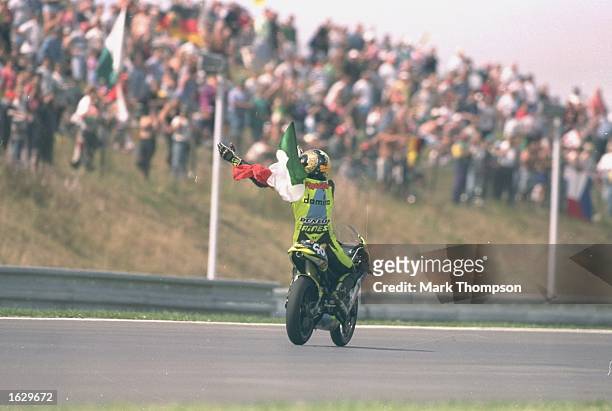 Valentino Rossi of Italy waves the Italian National flag from his Aprilia after winning the 125cc class of the Czech Grand Prix at the Brno circuit...