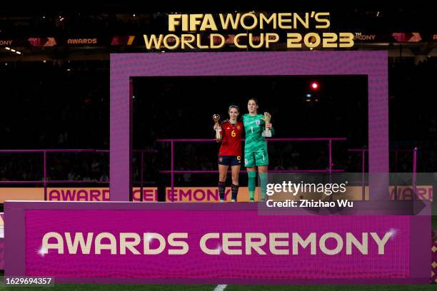 Aitana Bonmati of Spain holds the Golden Ball Trophy, as Mary Earps of England presents the Golden Glove Trophy during the award ceremony of the FIFA...