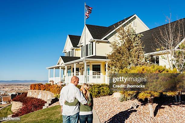 young couple with new home - big hug stock pictures, royalty-free photos & images