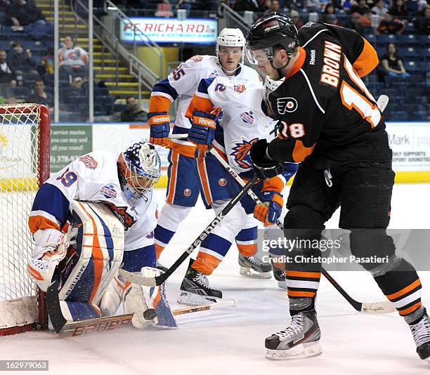Rick DiPietro of the Bridgeport Sound Tigers makes a save against Tyler Brown of the Adirondack Phantoms an American Hockey League game on March 2,...