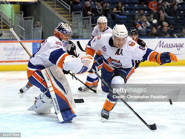 Nathan McIver of the Bridgeport Sound Tigers clears the puck from in front of Rick DiPietro during an American Hockey League game against the...
