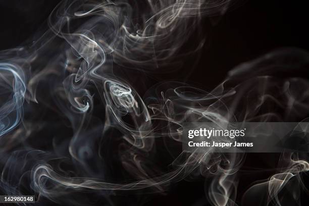 smoke  curls against black background - 煙 ストックフォトと画像