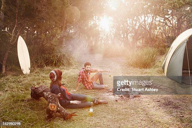 couble camping around smokey fire on sunset - camping new south wales stock pictures, royalty-free photos & images