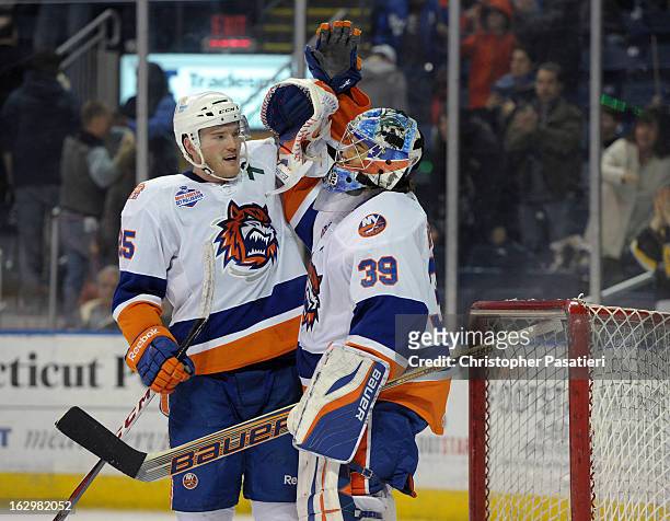 Rick DiPietro of the Bridgeport Sound Tigers is congratulated by Jordan Hill after defeating the Adirondack Phantoms during an American Hockey League...