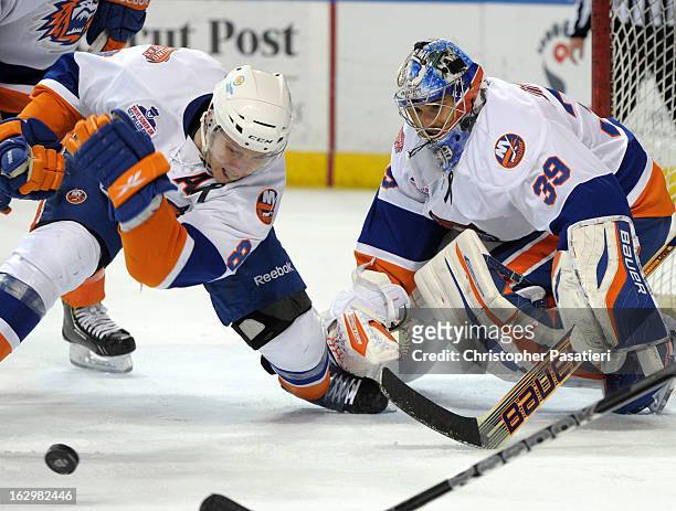 Rick DiPietro of the Bridgeport Sound Tigers watches as Nathan McIver clears the puck from the front of the net during an American Hockey League game...