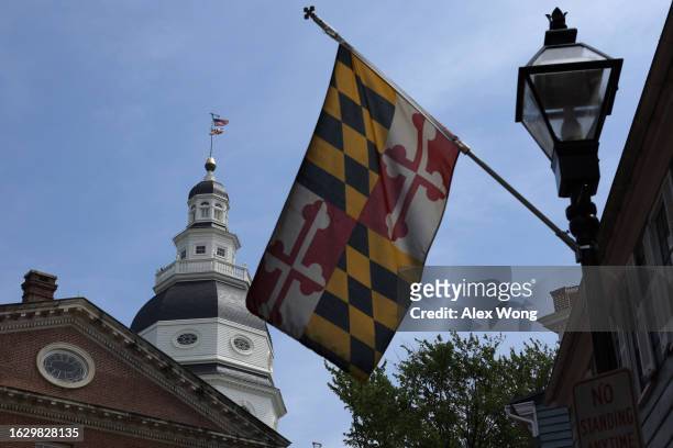 As a Maryland State flag flies in the foreground, the Maryland State House is seen on August 21, 2023 in Annapolis, Maryland. The Maryland State...