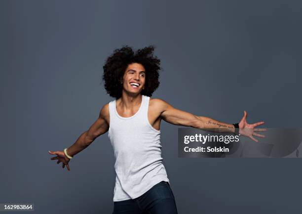 young man stretching out arms, studio background - camiseta de tirantes fotografías e imágenes de stock