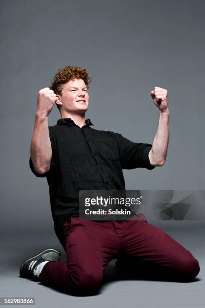 young man in victory pose, studio background - man cheering foto e immagini stock