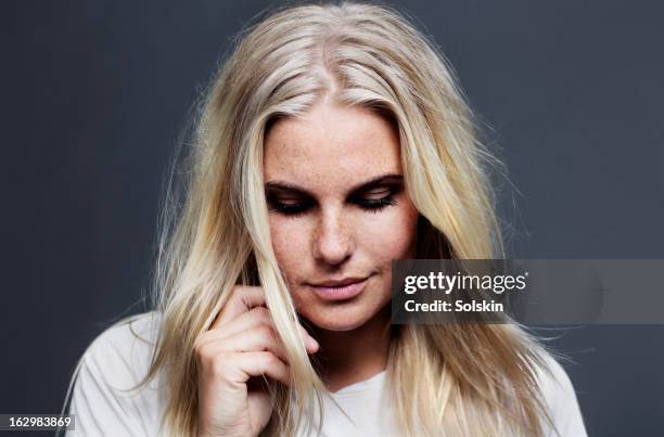 portrait of young woman, studio background - hand in den haaren stock-fotos und bilder