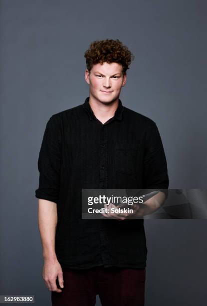 young man holding tablet, studio background - black shirt stockfoto's en -beelden
