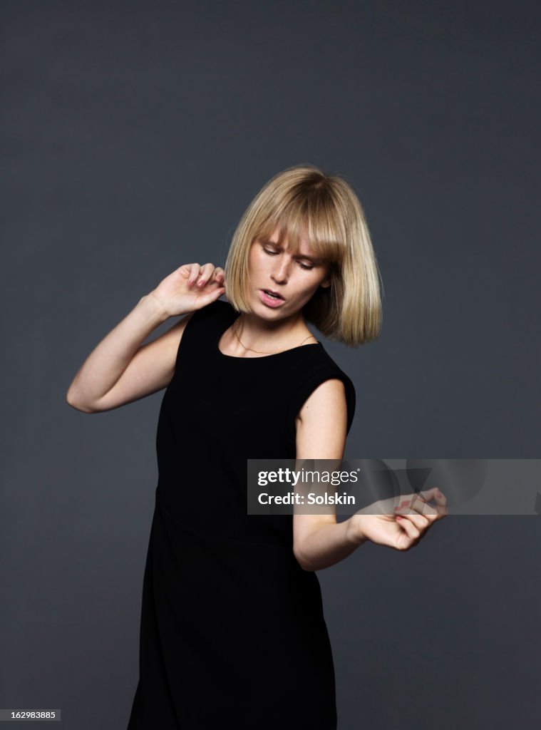 Young woman dancing in front of studio background