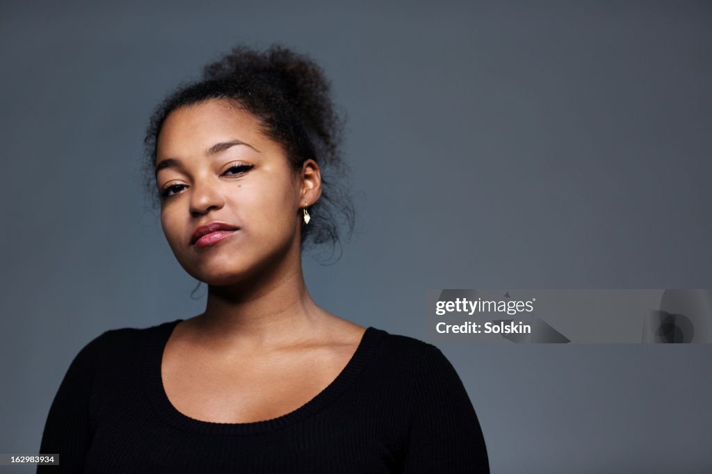 Portrait of young woman, studio background
