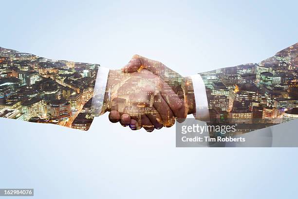 business men shaking hands with city view at night - agreement stock-fotos und bilder