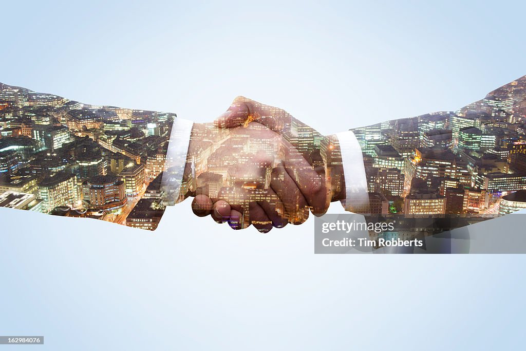 Business men shaking hands with city view at night