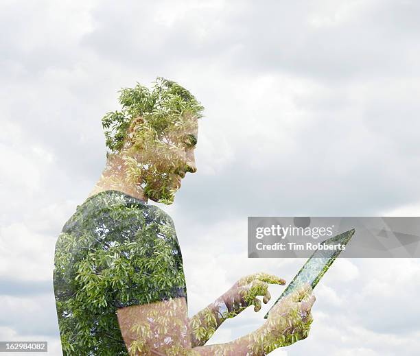 man using digital tablet with tree. - environment stock pictures, royalty-free photos & images