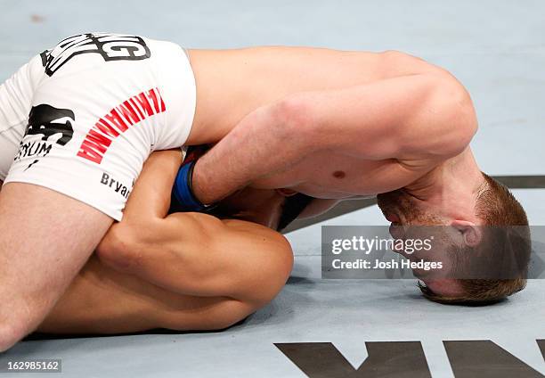 Bryan Caraway attempts to submit Takeya Mizugaki with a guillotine choke in their bantamweight fight during the UFC on FUEL TV event at Saitama Super...