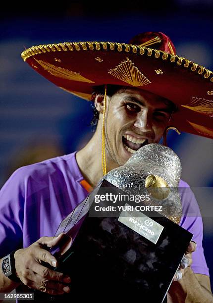 Rafael Nadal of Spain wears a traditional Mexican mariachi hat while holding the winning trophy after defeating his compatriot David Ferrer at the...